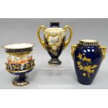 A cream and blue, gilt decorated, twin handled vase, with painted landscapes to opposing sides, 5.