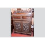 An excellent profusely carved rosewood bookcase cabinet having twin carved glazed doors to the top