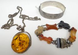 A bright-cut silver bangle, an agate and silver bracelet and an oval amber pendant