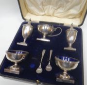 A cased silver and Bristol-blue glass condiment set comprising pair of square-based urn form