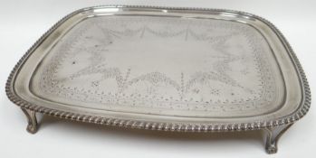 A George III bright-cut silver card-tray of rounded rectangular form, on four corner scrolled feet