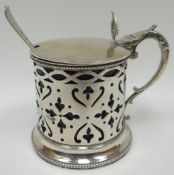 A Victorian pierce-work silver mustard pot with Bristol-blue glass liner and having scrolled