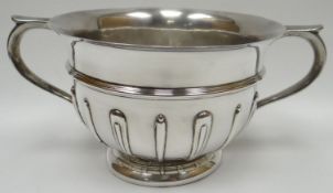 A twin handled silver trophy bowl on circular foot with fluted decoration to body, Birmingham