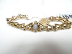 A 9ct yellow gold fancy-link bracelet with centre oval opal and flanked by four circular opals to