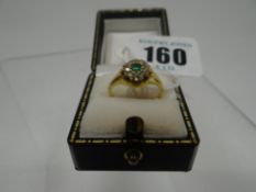 An 18ct yellow gold ring set with a emerald and diamond floral cluster, 3.5gms