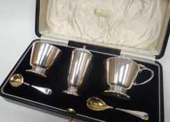 A cased Harrod's of London silver condiment set comprising salt, pepperette, and mustard-pot, all of