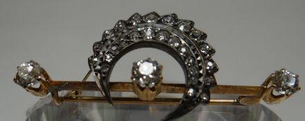 A multi-diamond bar brooch, with the bar having a row of three diamonds, approx 0.3cts each, below a