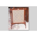 An Edwardian mahogany framed silk fronted firescreen with turned supports on arched feet, 31 x 22