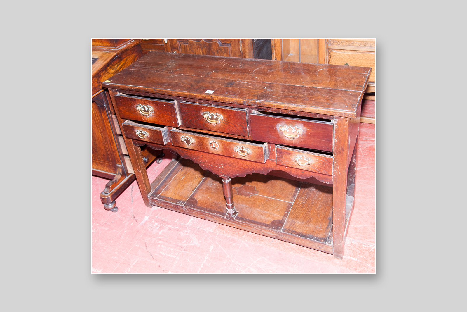 A late 19th Century oak Welsh dresser base having a bank of six small drawers furnished with brass