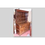 An antique oak and pine flat fronted Welsh dresser with three shelf Delft rack above, a good