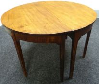 A Georgian d-end mahogany dining table with three extending leaves and on reeded tapered supports,