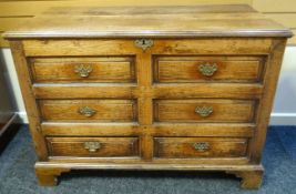 An early nineteenth century oak Lancashire chest with hinged plank-top lid above a brass furnished