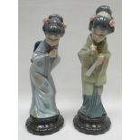 A pair of Lladro standing geisha on circular bases, 11.5ins high (29cms)