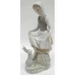 A Lladro figure of a farm girl with a hare on a naturalistic base, 9.5ins high (24cms)