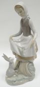 A Lladro figure of a farm girl with a hare on a naturalistic base, 9.5ins high (24cms)