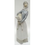 A Lladro figure of a farm-girl holding lamb in her arms, 11ins high (28cms)