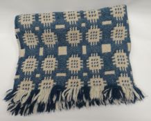 A blue and white patterned traditional Welsh blanket from Solva Woollen Mill
