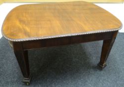 A turn-of-the-century extending mahogany dining table having three leaves, feather carving to the