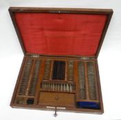 A wooden cased near-complete 'Opthalmic Optician' lense set with cushion interior and gilt
