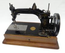 A nineteenth century Wheeler & Wilson sewing machine with wooden carry-case