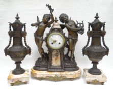 A French spelter and pink marble clock garniture. With two dancing cherubs flanking the raised