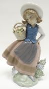 A Lladro figure of a girl picking flowers for her basket, 7ins high (18cms)