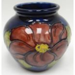A Moorcroft blue ground tube-lined floral squat baluster vase, 3ins high (8cms)