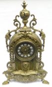 A gilt cast-metal mantel-clock in the Baroque-style with circular dial bearing Roman numerals,