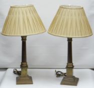 A pair of modern reproduction brass table lamps of Corinthian column form and on stepped square