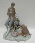 A Lladro model of a Regency courting couple, picking flowers for a basket, on a naturalistic base,