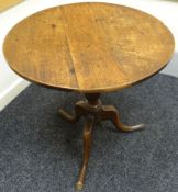 A tilt-top oak antique tripod table