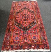 A hand-woven Iranian Hamadan rug in red ground, 49 x 89 (125 x 226cms)