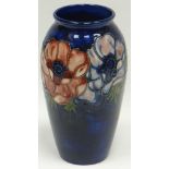 A Walter Moorcroft blue-ground tube-lined floral baluster vase with narrow neck, 7.5ins high (