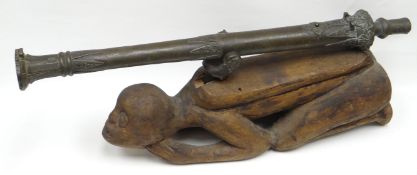 A bronze Lantaka-type cannon with decorative features on exotic wooden carved grotesque-character
