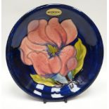 A Walter Moorcroft blue-ground tube-lined floral dish, 7.5ins diam (19cms)