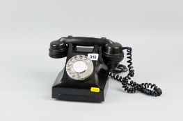A vintage black Bakelite telephone with chrome number dial (converted for modern connection)
