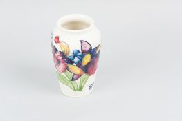 A Moorcroft pottery cream ground tapering vase, tube line decorated in the orchid pattern, impressed