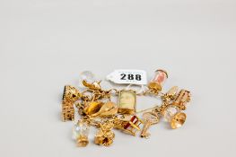A 9ct gold link charm bracelet with safety chain, padlock and approx 15 charms, 72.5 gms gross