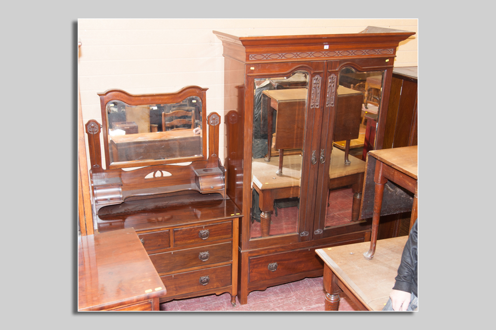 An Edwardian red walnut two piece bedroom suite comprising a double door mirrored wardrobe with