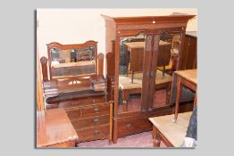 An Edwardian red walnut two piece bedroom suite comprising a double door mirrored wardrobe with