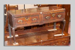 A compact 18th Century oak dresser base having two long drawers with brass drop handles and brass