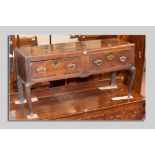 A compact 18th Century oak dresser base having two long drawers with brass drop handles and brass