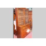 A large 19th Century oak bookcase cupboard, the upper section having twin glazed doors each with six