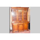 A Victorian mahogany three door bookcase, three glazed top doors below a shaped cornice with three