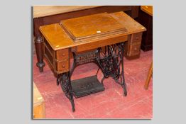 A Singer sewing machine oak table with cast iron treadle base, 78 x 90 cms