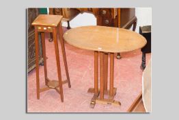 An oak oval topped Arts & Crafts style table with inlaid stringing to the top and simple carved