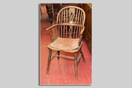 A Windsor splat and spindle backed elm elbow chair with turned supports and stretchers