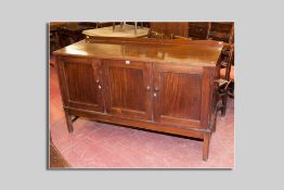 A Victorian mahogany sideboard having three doors with inset panels, two doors revealing four