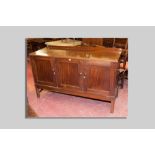 A Victorian mahogany sideboard having three doors with inset panels, two doors revealing four