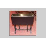 An Edwardian ebonised Sutherland table, twin flaps with canted corners, turned supports and